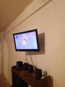 a flat screen tv hanging on a wall with speakers at Como en Casa in Caracas