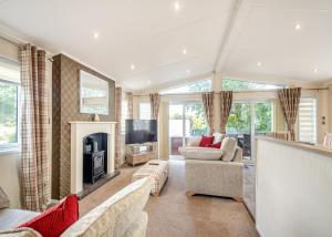 a living room with a fireplace and a tv at Brighouse Bay Holiday Park in Kirkcudbright