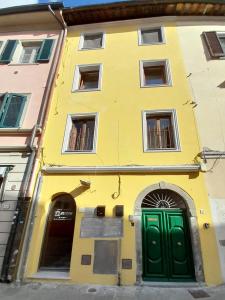 een geel gebouw met een groene deur in een straat bij Casa Torre San Lorenzo in Pisa