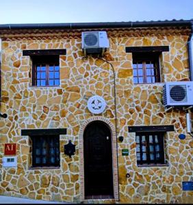 un edificio con un reloj al costado. en Casa RuralRut en El Tiemblo, zona de baño natural muy cercana y a solo 50 min de Madrid en El Tiemblo