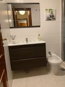 een badkamer met een wastafel, een toilet en een spiegel bij El Medano by Agüita Salada Suites in El Médano
