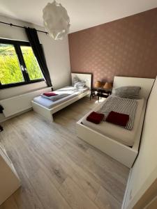 sypialnia z 2 łóżkami i dużym oknem w obiekcie Relaxen am Waldesrand Fewo 1 w mieście Ahrbrück