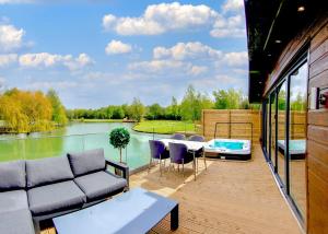 a patio with a couch and a table and a lake at Noahs Retreat in Laceby