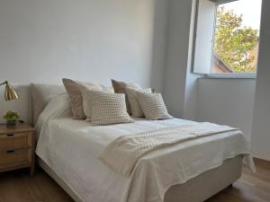 a white bed in a room with a window at Appartamento con terrazzo in Orvieto