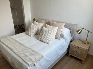 a white bed with pillows and a lamp on a table at Appartamento con terrazzo in Orvieto