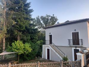 uma casa branca com uma escada ao lado de uma cerca em La Casa del Mugnaio em Rotonda