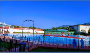 a large swimming pool with people in the water at GREDOS RURALRUT en El Tiemblo a solo 1 hora de Madrid, descuentos agosto y septiembre, zonas de baño y ocio a pocos metros, Reservas Naturales, cabina hidromasaje, Aire Acondicionado, WIFI incluido in El Tiemblo