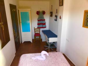 Cette chambre comprend deux lits, une table et une chaise. dans l'établissement CUEVA EL DUENDE, à Grenade