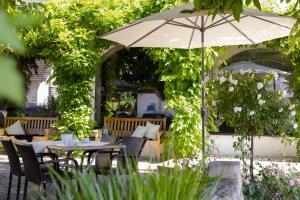 - une table avec un parasol dans le jardin dans l'établissement Pension Auszeit, à Langenargen