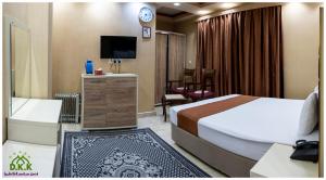 Habitación de hotel con cama y TV en Dur Kassir Alkadhimiya Hotel, en Karbala