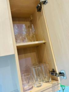 um armário cheio de copos vazios numa prateleira em Lovely CroydonCentral apartment em Croydon