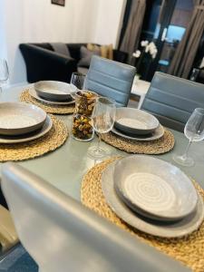 a table with plates and wine glasses on it at Lovely CroydonCentral apartment in Croydon