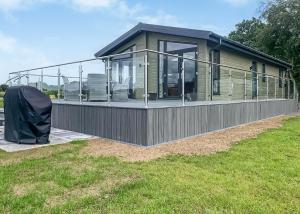 a modular home with a large glass porch on a lawn at Lakeside Luxury Lodges in Thorney