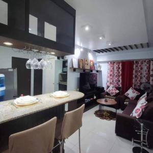 Il comprend une cuisine et un salon avec un bar et un canapé. dans l'établissement Near Manila Airport, MAILZ HOMEZ COZY 2 Bedroom Condo, Full Kitchen, Swimming Pool, WIFI, 4R, à Manille