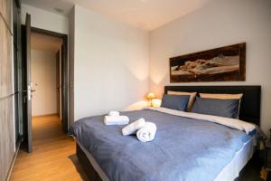 a bedroom with a large bed with towels on it at AEGLI Central Luxury Apartment in Alexandroupoli