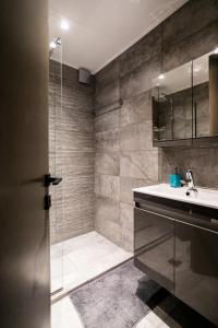 a bathroom with a sink and a shower at AEGLI Central Luxury Apartment in Alexandroupoli