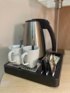 two coffee cups on a tray with a coffee pot at Budapest Citi Guesthouse - self check in in Budapest