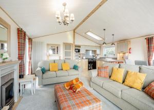 a living room with two couches and a kitchen at Brighouse Bay Holiday Park in Kirkcudbright