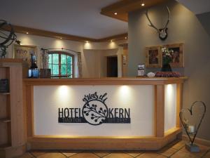 a hotel reception counter with a sign on it at Hotel Garni Kern in Halfing
