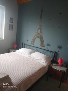 sypialnia z łóżkiem z wieżą Eiffel na ścianie w obiekcie Panaritis w Nauplionie