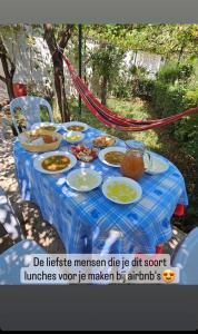 a blue table with plates of food on it at Kasaj Villa in Gjirokastër