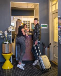 een man en een vrouw die aan een balie staan bij Neptun Badacsony in Badacsonytomaj