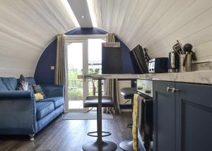 a living room with a blue couch and a table at Peacock Lake Glamping in East Bridgford