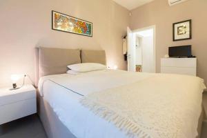 um quarto com uma cama branca e uma televisão em Luxury Flat Design District em Milão