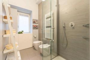 uma casa de banho com um WC e uma cabina de duche em vidro. em Luxury Flat Design District em Milão