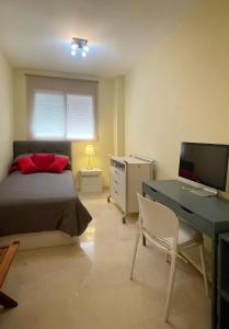 um quarto com uma cama e uma secretária com um computador em Work and Rest Away From Home em Paterna