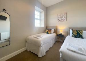 a small room with two beds and a mirror at Haveringland Hall in Cawston