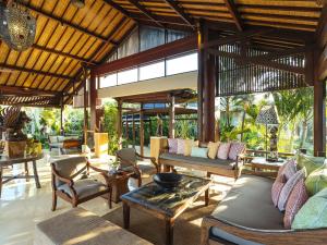 an outdoor living room with couches and chairs at Villa Semarapura in Canggu
