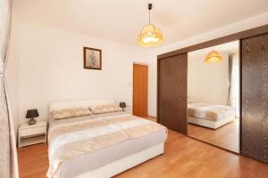 a bedroom with a large bed and a mirror at Maribela Apartments in Trogir