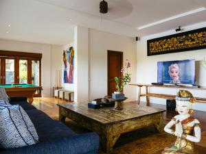 a living room with a couch and a table at Villa Semarapura in Canggu