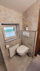 a bathroom with a white toilet and a window at Apartment Neuhaushof in Westendorf