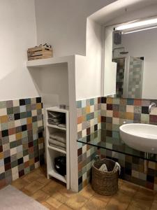 La salle de bains est pourvue d'un lavabo et d'un miroir. dans l'établissement Bella Casa Affrescata, à Orvieto