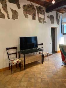 - un piano et une chaise dans une chambre avec une télévision dans l'établissement Bella Casa Affrescata, à Orvieto