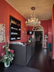 a restaurant with red walls and a chandelier at Hotel Ascot in Caianello