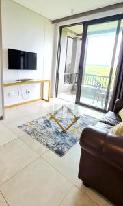 a living room with a glass table and a couch at Zimbali Lakes Boulevard Suites in Ballito