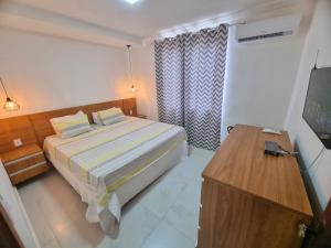 um quarto com uma cama e uma televisão em TH Flats GV Shopping 301 em Governador Valadares