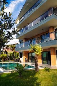 a building with a palm tree next to a swimming pool at LUXURY VILLA FOUR FOURLEX (YALOVA) in Termal