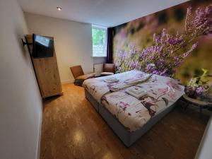 ein Schlafzimmer mit einem Bett, einem TV und Blumen in der Unterkunft Herberg De Eexter Os in Eext