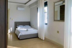 um quarto branco com uma cama e um espelho em LUXURY VILLA FOUR FOURLEX (YALOVA) em Termal