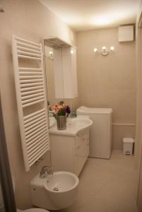 een badkamer met een toilet, een wastafel en een spiegel bij Ca' Priuli 1 in Venetië