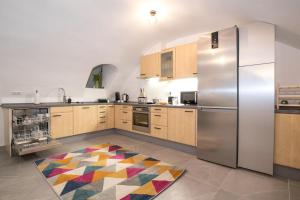 eine Küche mit einem Kühlschrank und einem bunten Teppich auf dem Boden in der Unterkunft Große. Moderne. Zentrale Wohnung in Lappersdorf