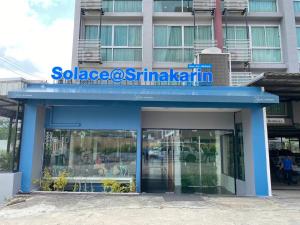 Solace at Srinakarin Hotel في بانغنا: مبنى أزرق تعلوه لافتة
