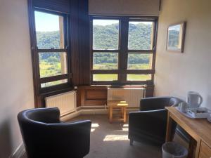 a room with two chairs and a large window at Plas Tan y Bwlch in Maentwrog