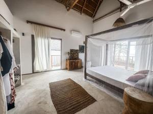 a bedroom with a bed and a large window at Villa Upendo with pool, Zanzibar in Pingwe