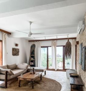 een woonkamer met een bank en een tafel bij Villa Upendo with pool, Zanzibar in Pingwe