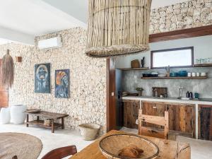 a living room with a table and a kitchen at Villa Upendo with pool, Zanzibar in Pingwe
